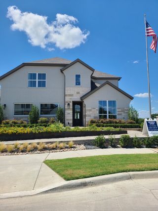 Model Home A modern two-story home with lush landscaping in Ten Mile Creek 55s by American Legend Homes (Celina, TX).