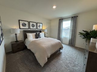 Model Home A spacious bedroom with a sleek neutral palette, stylish décor, and ample natural light.
