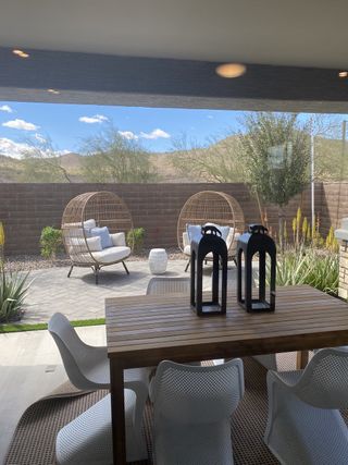 Model Home A bright laundry room features white cabinets with dark hardware, a white Whirlpool washer and dryer, a woven basket with folded towels, and light wood-look tile flooring.