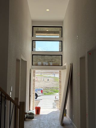 Model Home A stunning two-story foyer with large windows bringing in natural light in Johnson Ranch by Perry Homes (Bulverde, TX).