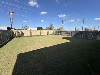 A spacious fenced backyard under a clear sky in Eastwood at Sonterra by Pacesetter Homes (Jarrell, TX).