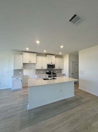 A sleek kitchen with white cabinetry, a spacious island, and modern finishes, offering an airy and inviting cooking space.