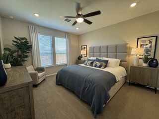 Model Home A cozy bedroom with a plush bed, stylish decor, large window, and modern lighting.