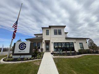 Street view A modern stone home with sleek windows and a landscaped yard in Enclave at Cele by GFO Home (Pflugerville, TX).