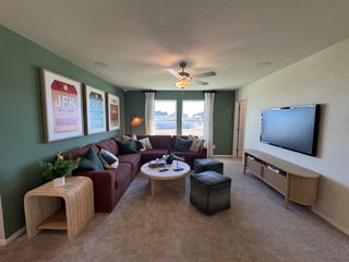 Model Home A cozy living room featuring a sectional sofa, stylish wall art, and a modern entertainment setup.