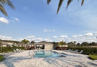 A second view of the sparkling pool, complete with shaded cabanas and lush greenery, perfect for outdoor enjoyment in Windrose by D.R. Horton (Apopka, FL).