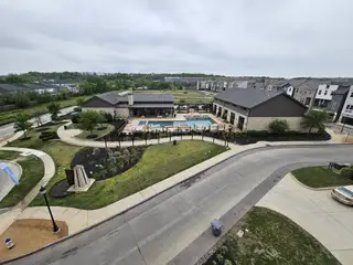 Community Amenities A modern community clubhouse with a pool and landscaped grounds in SoHo Square by Megatel Homes (Dallas, TX).