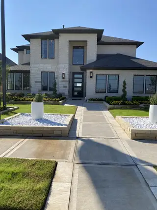 A modern stone home with sleek lines and lush landscaping in StoneCreek Estates 50' by Perry Homes (Richmond, TX).