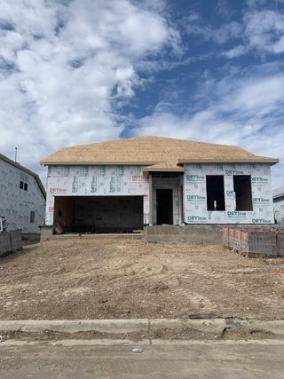 Street view A new construction home is taking shape in Waterstone: Stonehill Collection by Lennar, Kyle, TX, under a bright blue sky.