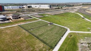 Community Amenities Aerial view of Mustang Valley by KB Home featuring spacious plots and manicured green spaces in Manor, TX.