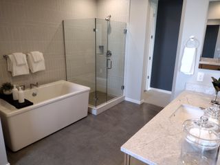 A sleek bathroom with a modern glass shower, freestanding tub, and elegant vanity in a neutral palette.