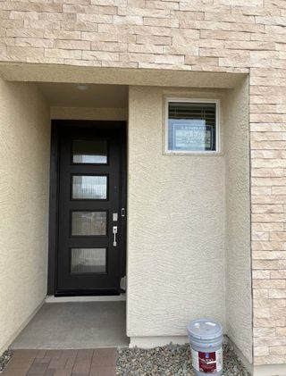 Street view A modern entrance with a sleek black door and stone accents in Avalon Crossing Inspiration by Lennar (Mesa, AZ).