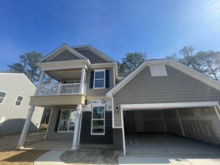 A charming two-story home with a garage and balcony in Ashley Cove by Eastwood Homes (Summerville, SC).