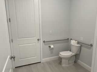 A modern bathroom featuring sleek gray walls, accessible fixtures, and light wood flooring for a fresh, clean look.