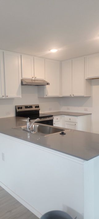 A sleek modern kitchen with white cabinetry, quartz countertops, and recessed lighting for a bright and open feel.