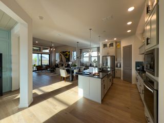 Model Home A spacious kitchen with sleek cabinetry, modern island, and open-plan layout flowing into a bright, elegant living area.