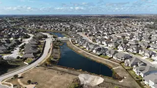 Community Amenities Aerial view of a picturesque community with winding streets and ponds in Oaks at San Gabriel by Brohn Homes (Georgetown, TX).