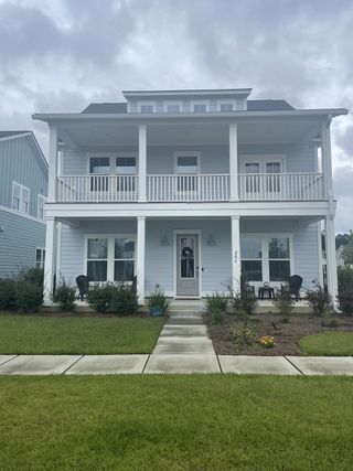 A charming two-story blue home with spacious porches in Carnes Crossroads by Lennar (Summerville, SC).