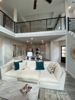 A sophisticated two-story living space with contemporary railings, open-concept design, and a stunning loft view.
