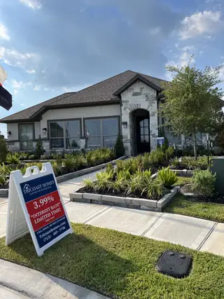 Street view A charming stone-accented home with lush landscaping in River Ranch 55' by Tricoast Homes, Dayton, TX.