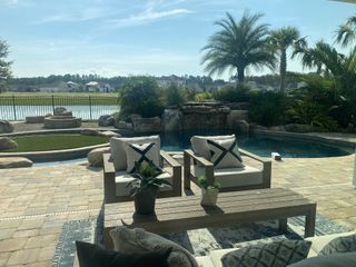 A serene backyard oasis with a lush pool view, cozy seating, and peaceful landscaping.