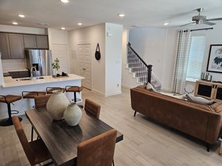 Model Home Open-plan interior with modern kitchen, cozy seating area, and stylish dining set. Bright and inviting space with natural light.