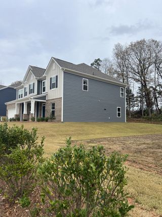 A modern gray home with white accents and landscaped frontage in Sanders Ridge by M/I Homes (Troutman, NC).
