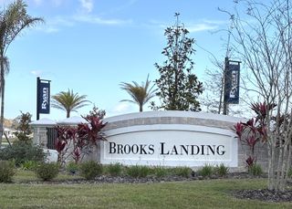 The welcoming sign for Brooks Landing, a new residential community with well-maintained landscaping and branding from Ryan Homes.