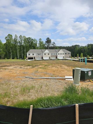 Street view Upcoming townhomes under construction with lush surroundings at Wildwood Place by Traton Homes in Powder Springs, GA.