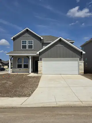 A modern gray home with a two-car garage in Cinco Lakes by Centex, featuring clean lines in San Antonio, TX.