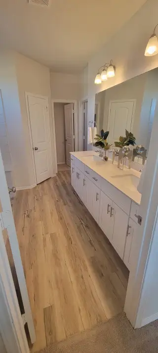 A stylish bathroom featuring dual sinks, modern fixtures, and a spacious layout with neutral tones.
