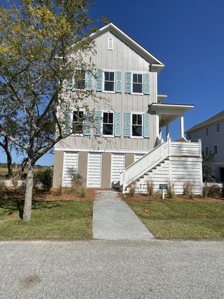 A charming three-story home with blue shutters in The Preserve at Pennys Creek by Brightwater Homes (Johns Island, SC).