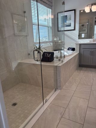 A luxurious bathroom featuring a glass shower, soaking tub, and elegant finishes for a serene retreat.