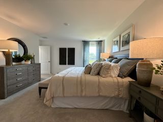 A cozy bedroom featuring a plush bed, elegant decor, warm lighting, and modern furnishings for a relaxing retreat.