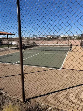A recreational tennis court at North Copper Canyon by Oakwood Homes Co in Surprise, AZ, surrounded by scenic desert views.