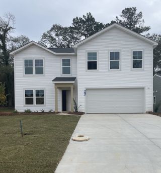 A modern white home with a sleek design and spacious driveway in Essence at Chandler Crossing by Stanley Martin Homes (Summerville, SC).