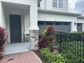 Street view A modern gray façade with stone accents and lush landscaping in Seasons at Wekiva Ridge by Richmond American Homes (Mount Dora, FL).