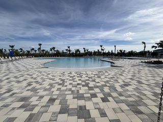 A spacious pool with a beautiful paver deck in Central Park Townhomes by D.R. Horton, Port St. Lucie, FL.
