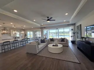 An open-plan living area with cozy seating, modern kitchen, and large windows showcasing serene outdoor views.