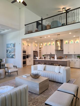 Model Home Elegant open-concept living area with high ceilings, modern kitchen, plush seating, and stylish décor.