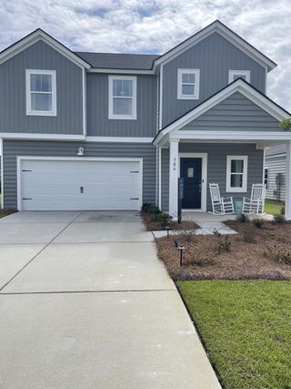 A charming gray home with a welcoming porch and two-car garage in Cypress Preserve: Arbor Collection by Lennar (Moncks Corner, SC).