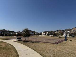 A well-maintained basketball court surrounded by a walking path, fostering an active lifestyle in Bluffview by Taylor Morrison (Leander, TX).
