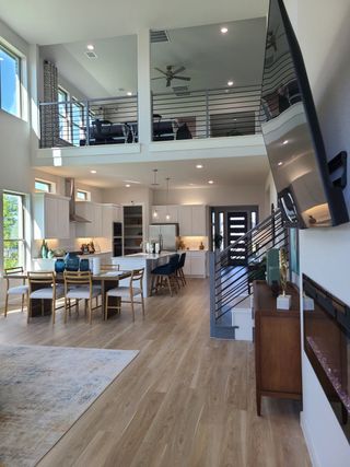 A modern open living space with high ceilings, elegant dining area, and contemporary finishes.