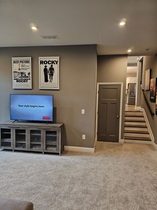 A cozy home theater space with plush seating, soft carpeting, and stylish decor, perfect for entertainment and relaxation.
