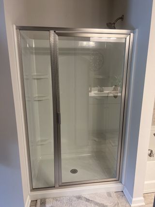 A sleek glass shower enclosure with chrome fixtures and bright, spacious interior.