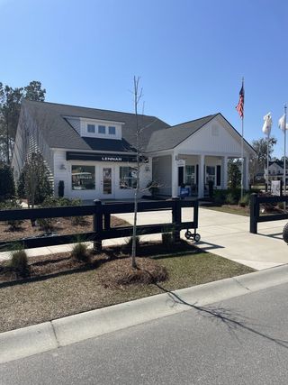 Street view A charming white home with a manicured lawn at Heron's Walk at Summers Corner by Lennar (Summerville, SC).