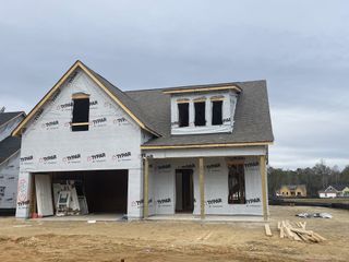 A contemporary home under construction in Timothy Lakes by Center Park Homes (Ridgeville, SC), with dormer windows and garage.