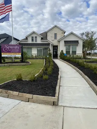 Street view A beautiful stone-accented home with landscaped path in Serenity at Meridiana 55' by Tricoast Homes (Manvel, TX).