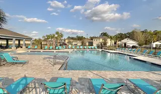 A resort-style pool with ample lounge seating and tropical landscaping in Concorde by D.R. Horton (Sanford, FL).