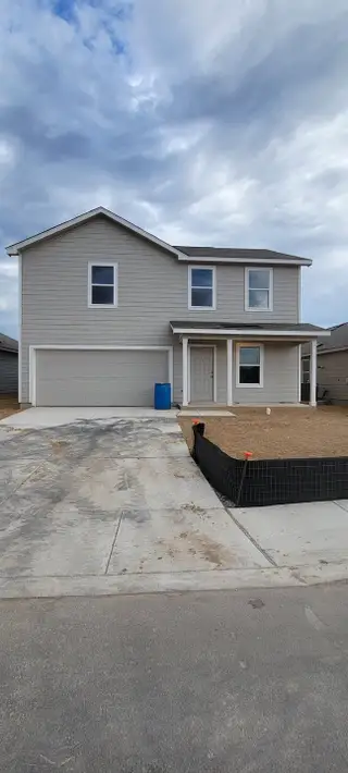 Street view A modern two-story home with a double garage in Torian Village: Cottage Collection by Lennar (San Antonio, TX).